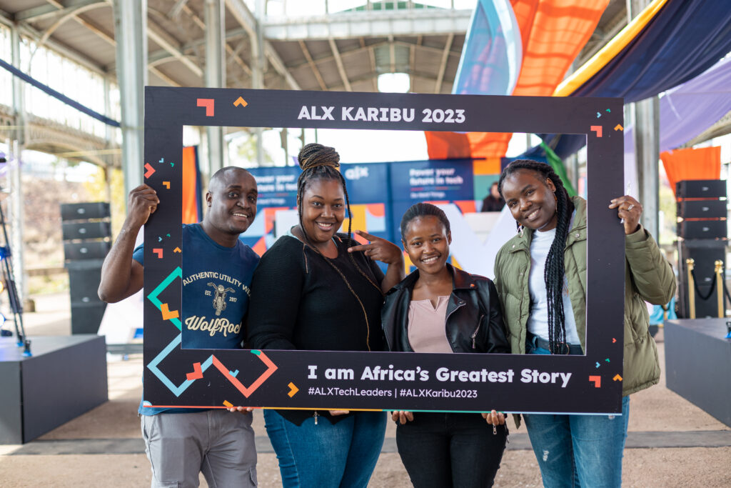 4 ALX learners holding a large frame prop | ALX Karibu 2023