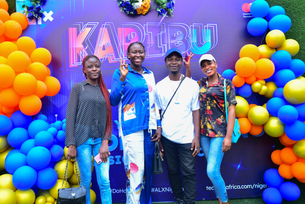4 ALX learners posing in front of a Karibu sign at the Karibu ceremony in Lagos