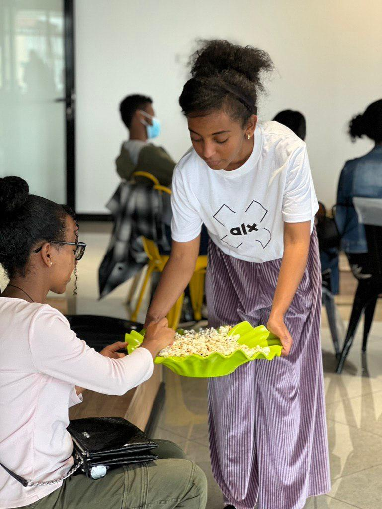ALX learner treating herself to some popcorn at the Nu Buna Tetu community event at the Addis Capstone Hub in Ethiopia