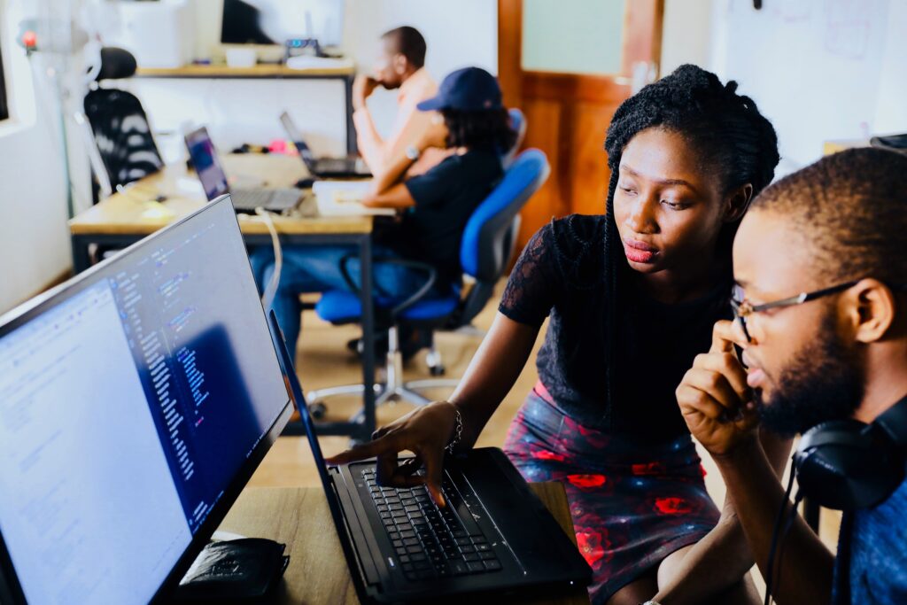 Woman and man sitting at a computer  and appearing to work together on some task.