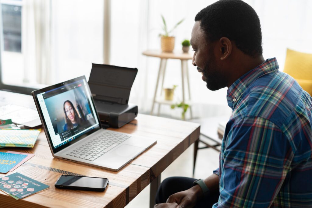 Man in blue plaid shirt on a video call with a woman.