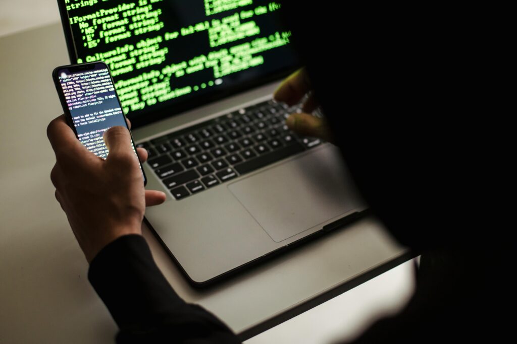 Software engineer working on their phone and laptop.