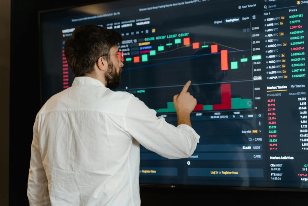 Man in white dress shirt looking at a computer screen with data points on it.