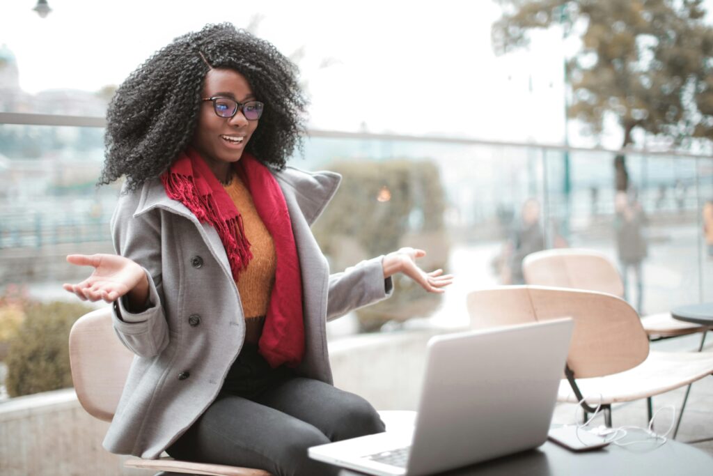 A woman sitting outside at her laptop during class at her university